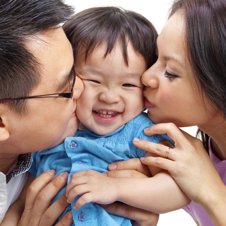 Parents kissing child