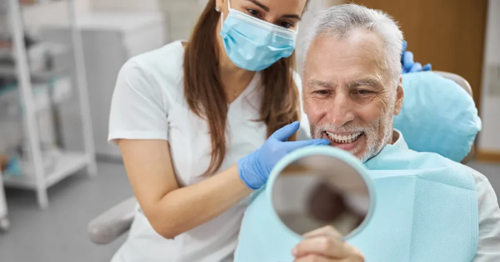 Man Looking At Dental Implants In Mirror